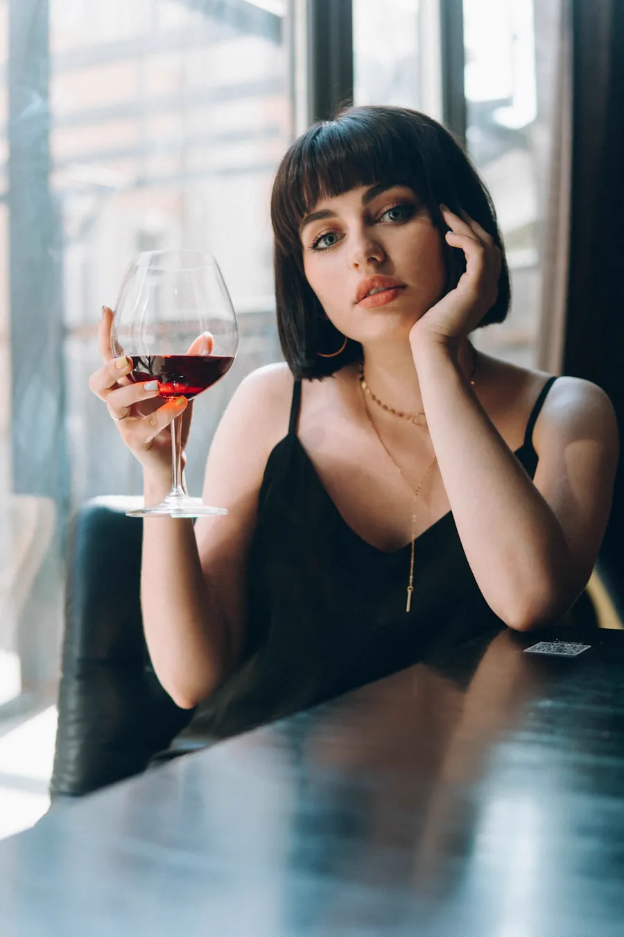 Ospite al tavolo con calice di vino